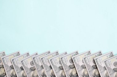Satır bir ABD dolar faturaları yeni bir tasarım üzerinde bir açık mavi renkli yatıyor.