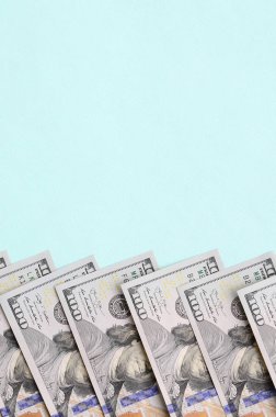 Satır bir ABD dolar faturaları yeni bir tasarım üzerinde bir açık mavi renkli yatıyor.