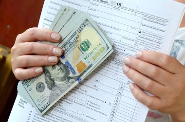 Kız onun elinde tutan vergi formu ve çok sayıda dolar faturaları.
