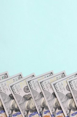 Satır bir ABD dolar faturaları yeni bir tasarım üzerinde bir açık mavi renkli yatıyor.