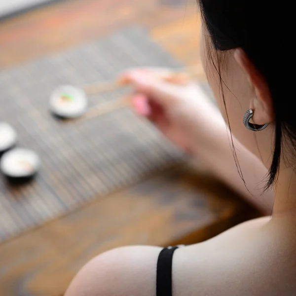 Brunetka Dziewczynka Pałeczkami Posiada Roll Sushi Tle Mata Słomy Serwing — Zdjęcie stockowe