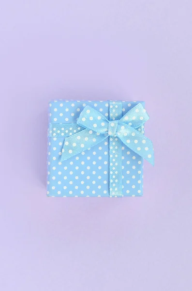 Kleine Blaue Geschenkschachtel Mit Schleife Liegt Auf Violettem Hintergrund Minimalismus — Stockfoto