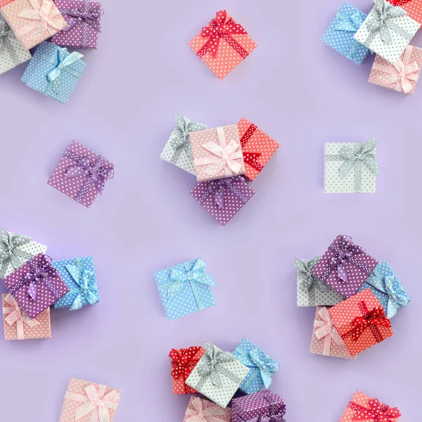 一堆带有丝带的小彩色礼品盒位于紫罗兰色的背景上 简约平躺顶视图模式 — 图库照片