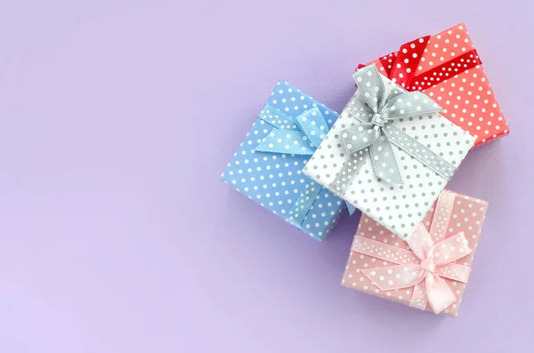 Auf Violettem Hintergrund Liegt Ein Stapel Kleiner Farbiger Geschenkboxen Mit — Stockfoto