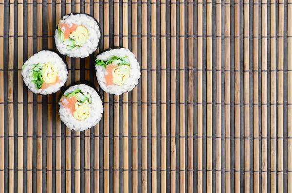 寿司卷位于竹秸秆 Serwing 传统的亚洲食品 顶部视图 平面平躺极简拍摄与复制空间 — 图库照片