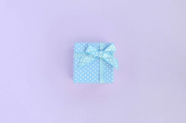 带丝带的蓝色小礼品盒位于紫罗兰色背景上 简约平躺顶视图 — 图库照片