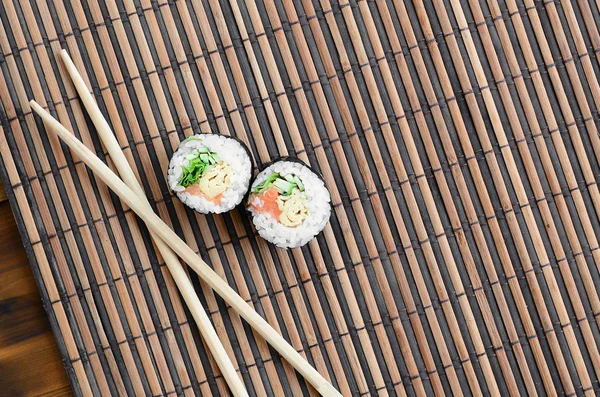 Rolos Sushi Pauzinhos Madeira Estão Tapete Serrar Palha Bambu Comida — Fotografia de Stock