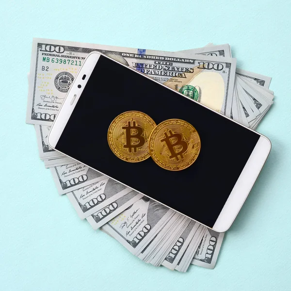 스마트폰 파란색 배경에 지폐에 Bitcoins 거짓말 — 스톡 사진