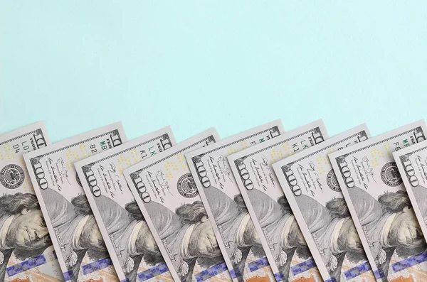 Satır bir ABD dolar faturaları yeni bir tasarım üzerinde bir açık mavi renkli yatıyor.