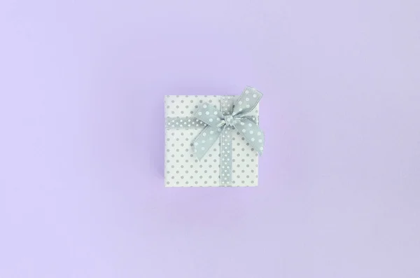 带丝带的白色小礼品盒位于紫罗兰色背景上 简约平躺顶视图 — 图库照片