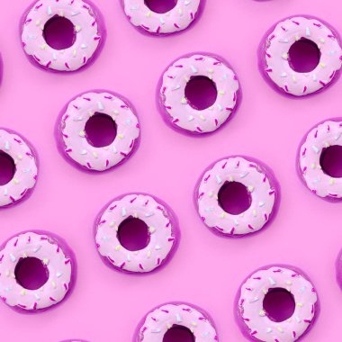 Birçok küçük plastik donuts bir pastel renkli arka plan üzerinde yatıyor. Düz yatıyordu en az desen. Üstten görünüm