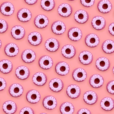 Birçok küçük plastik donuts bir pastel renkli arka plan üzerinde yatıyor. Düz yatıyordu en az desen. Üstten görünüm