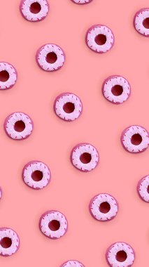 Birçok küçük plastik donuts bir pastel renkli arka plan üzerinde yatıyor. Düz yatıyordu en az desen. Üstten görünüm