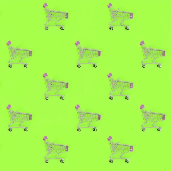 Einkaufssucht, Shopping-Liebhaber oder Shopaholic-Konzept. viele kleine leere Einkaufswagen führen ein Muster auf pastellfarbenem Papierhintergrund aus. flache Verlegekomposition, Ansicht von oben — Stockfoto