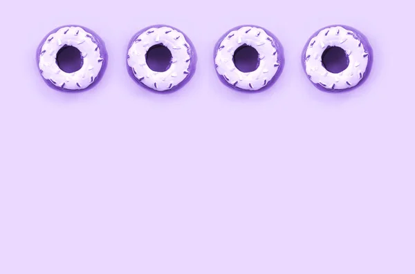 Muchos pequeños donuts de plástico se encuentra en un fondo de colores pastel. Piso establecer un patrón mínimo. Vista superior — Foto de Stock