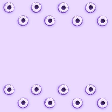 Birçok küçük plastik donuts bir pastel renkli arka plan üzerinde yatıyor. Düz yatıyordu en az desen. Üstten görünüm