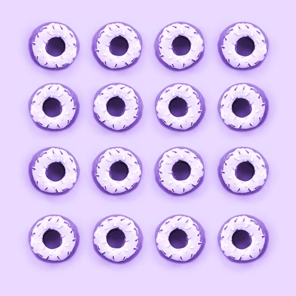 Muchos pequeños donuts de plástico se encuentra en un fondo de colores pastel. Piso establecer un patrón mínimo. Vista superior — Foto de Stock