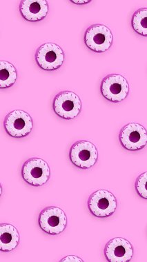 Birçok küçük plastik donuts bir pastel renkli arka plan üzerinde yatıyor. Düz yatıyordu en az desen. Üstten görünüm