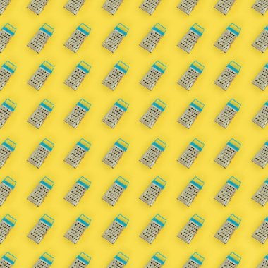 Küçük paslanmaz çelik rende renkli kağıt üzerine pastel yatıyor. Mutfak aksesuarları. Yemek pişirmek için araçlar. Düz yatıyordu üstten görünüm