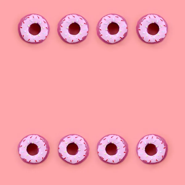 Многие маленькие пластиковые пончики лежат на пастельном красочном фоне. Плоский лежал минимальный шаблон. Вид сверху — стоковое фото