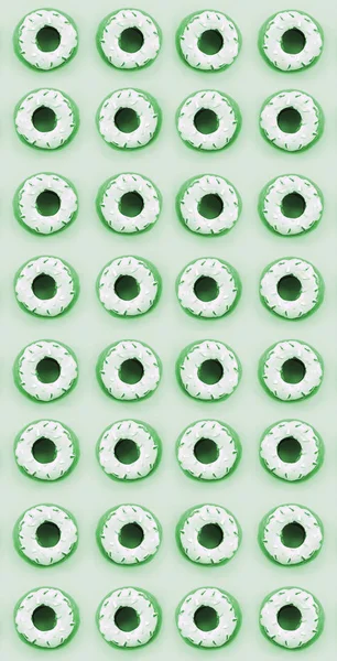 多くの小さなプラスチック製のドーナツは、パステル調のカラフルな背景にあります。フラット レイアウトの最小パターン。トップ ビュー — ストック写真