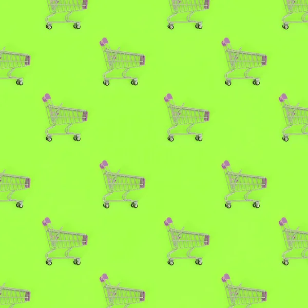 Nákupní závislost, milence nebo shopaholic koncept nákupu. Mnoho malých prázdný nákupní vozíky provést vzorek na pastelové barevné papírové pozadí. Plochá laických složení, pohled shora — Stock fotografie