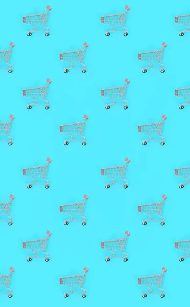 Nákupní závislost, milence nebo shopaholic koncept nákupu. Mnoho malých prázdný nákupní vozíky provést vzorek na pastelové barevné papírové pozadí. Plochá laických složení, pohled shora — Stock fotografie