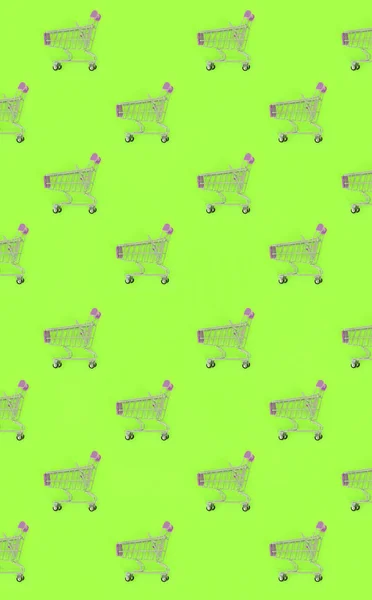 Shopping addiction, shopping lover or shopaholic concept. Many small empty shopping carts perform a pattern on a pastel colored paper background. Flat lay composition, top view — Stock Photo, Image