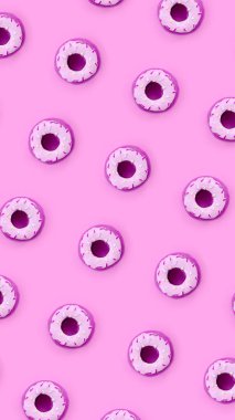 Birçok küçük plastik donuts bir pastel renkli arka plan üzerinde yatıyor. Düz yatıyordu en az desen. Üstten görünüm