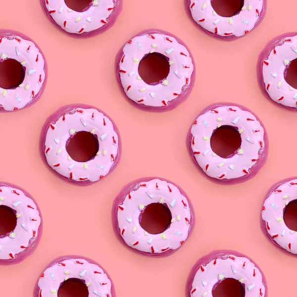 Birçok küçük plastik donuts bir pastel renkli arka plan üzerinde yatıyor. Düz yatıyordu en az desen. Üstten görünüm