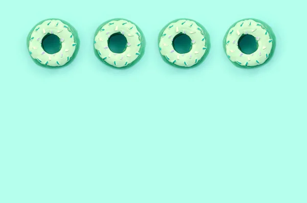 Many small plastic donuts lies on a pastel colorful background. Flat lay minimal pattern. Top view — Stock Photo, Image