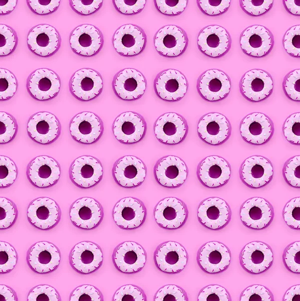 Molte piccole ciambelle di plastica si trova su uno sfondo colorato pastello. Flat lay modello minimale. Vista dall'alto — Foto Stock