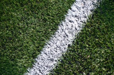 Parlak yeşil yeşil çimen futbol sahasında beyaz şerit.