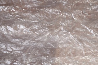 Doku yüzeyinin beyaz buruşuk selofan saydam güneş ışığı. Paketleme, neden olduğu zararlara karşı ürün koruma malzemeleri kavramı