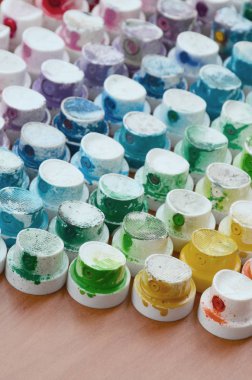 Bir çok farklı renklere bulaşmış grafiti çizim için bir boya püskürtme başlıklarından bir desen. Plastik kapaklar gökkuşağı rengi oluşturan birçok satır düzenlenir