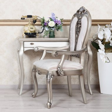 Bir sandalye ve bir masa üzerine retro bir iç bir parçası olan telefon ve kenarındaki çiçek dolu vazolar yer alır