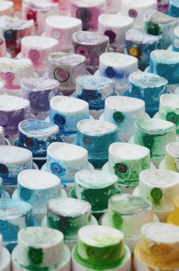 Bir çok farklı renklere bulaşmış grafiti çizim için bir boya püskürtme başlıklarından bir desen. Plastik kapaklar gökkuşağı rengi oluşturan birçok satır düzenlenir