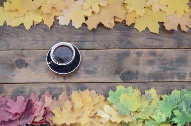 Arka plan koyu kahverengi renk doğal ahşap kurullarında yüzeyinde düşmüş sonbahar sararma kümesi arasında çay yaprakları