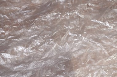 Doku yüzeyinin beyaz buruşuk selofan saydam güneş ışığı. Paketleme, neden olduğu zararlara karşı ürün koruma malzemeleri kavramı