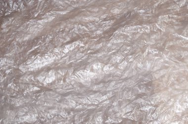 Doku yüzeyinin beyaz buruşuk selofan saydam güneş ışığı. Paketleme, neden olduğu zararlara karşı ürün koruma malzemeleri kavramı