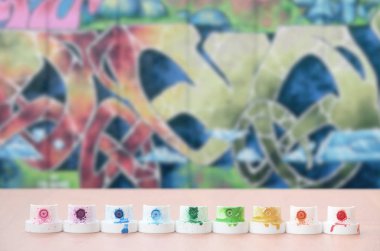 Kirli çok renkli boya püskürtme başlıklarından renkli grafiti çizim vahşi bir tarzda bir arka plan üzerinde ahşap bir masa üzerinde sıralanır. Sokak sanatı kavramı