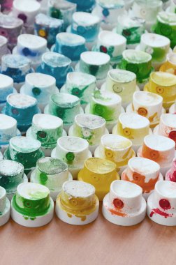 Bir çok farklı renklere bulaşmış grafiti çizim için bir boya püskürtme başlıklarından bir desen. Plastik kapaklar gökkuşağı rengi oluşturan birçok satır düzenlenir
