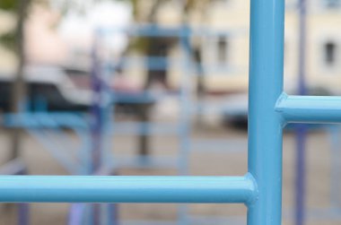 Mavi metal borular ve çapraz-barlar sokak spor alanında eğitim Atletizm için karşı. Açık atletik spor salonu ekipman. Makro fotoğraf seçici odak ve son derece bulanık arka plan ile