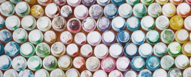 Bir çok farklı renklere bulaşmış grafiti çizim için bir boya püskürtme başlıklarından bir desen. Plastik kapaklar gökkuşağı rengi oluşturan birçok satır düzenlenir