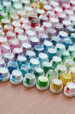 Bir çok farklı renklere bulaşmış grafiti çizim için bir boya püskürtme başlıklarından bir desen. Plastik kapaklar gökkuşağı rengi oluşturan birçok satır düzenlenir