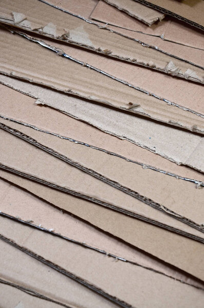 Background image with a lot of beige cardboard paper, which is used to make boxes for the transport of home appliances and postal parcels. Carton texture