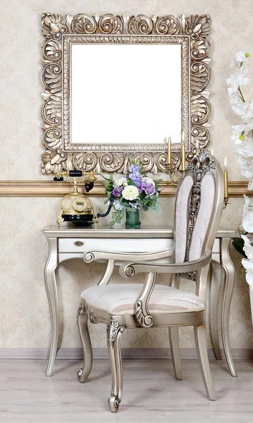 一个带有椅子和桌子的复古内饰的碎片 上面是电话和花瓶 在桌子上面挂一个空的图片框架为您的照片 — 图库照片
