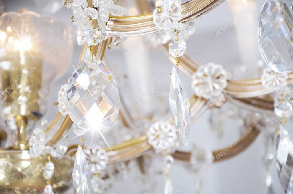 Close-up photo of the scenery on the old chandelier. Glass figures shine and reflect light with their faces