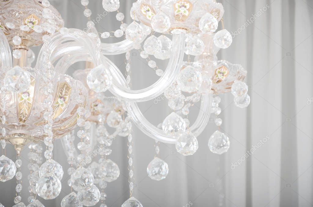 Close-up photo of the scenery on the old chandelier. Glass figures shine and reflect light with their faces