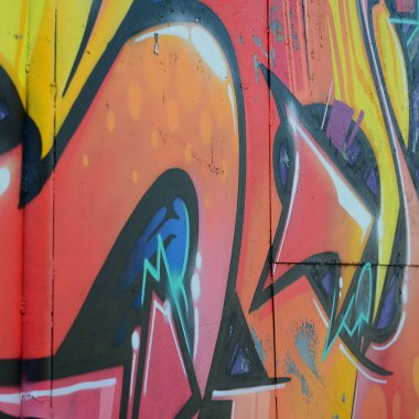 Grafiti çizimler parçası. Eski duvar boya lekeleri sokak sanatı kültür tarzı ile dekore edilmiştir. Renkli arka plan doku sıcak tonları içinde.